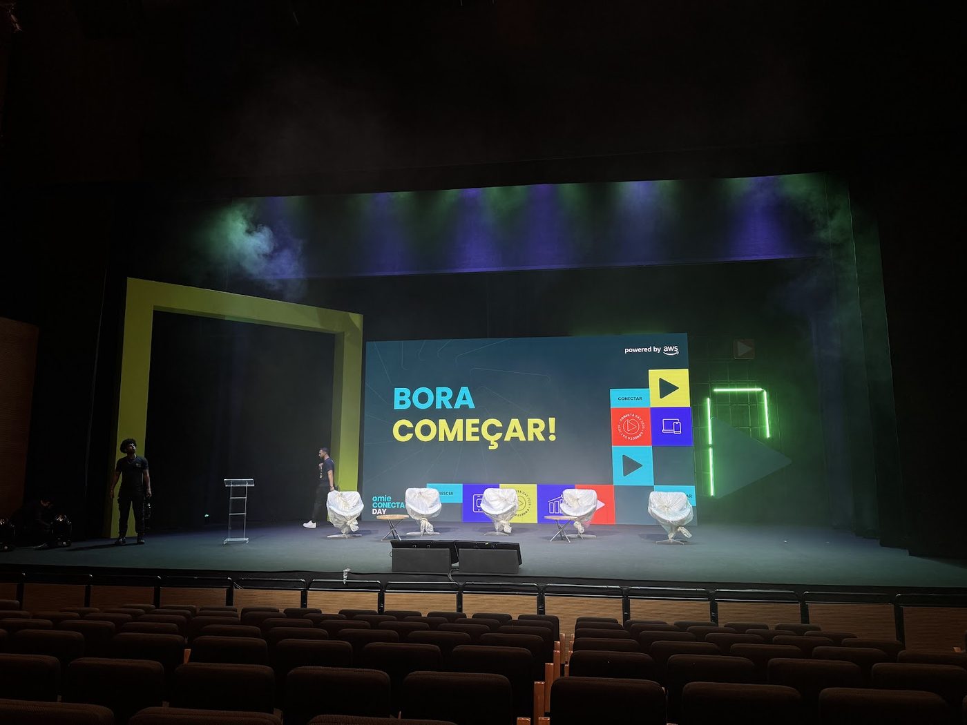 Auditório corporativo vazio com painel de LED central e poltronas organizadas para convenção