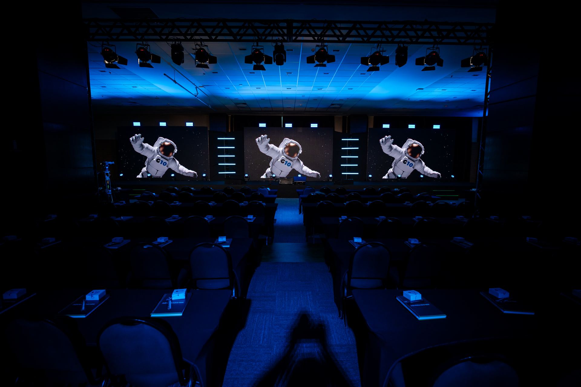 Painel LED em evento corporativo com palco e apresentador