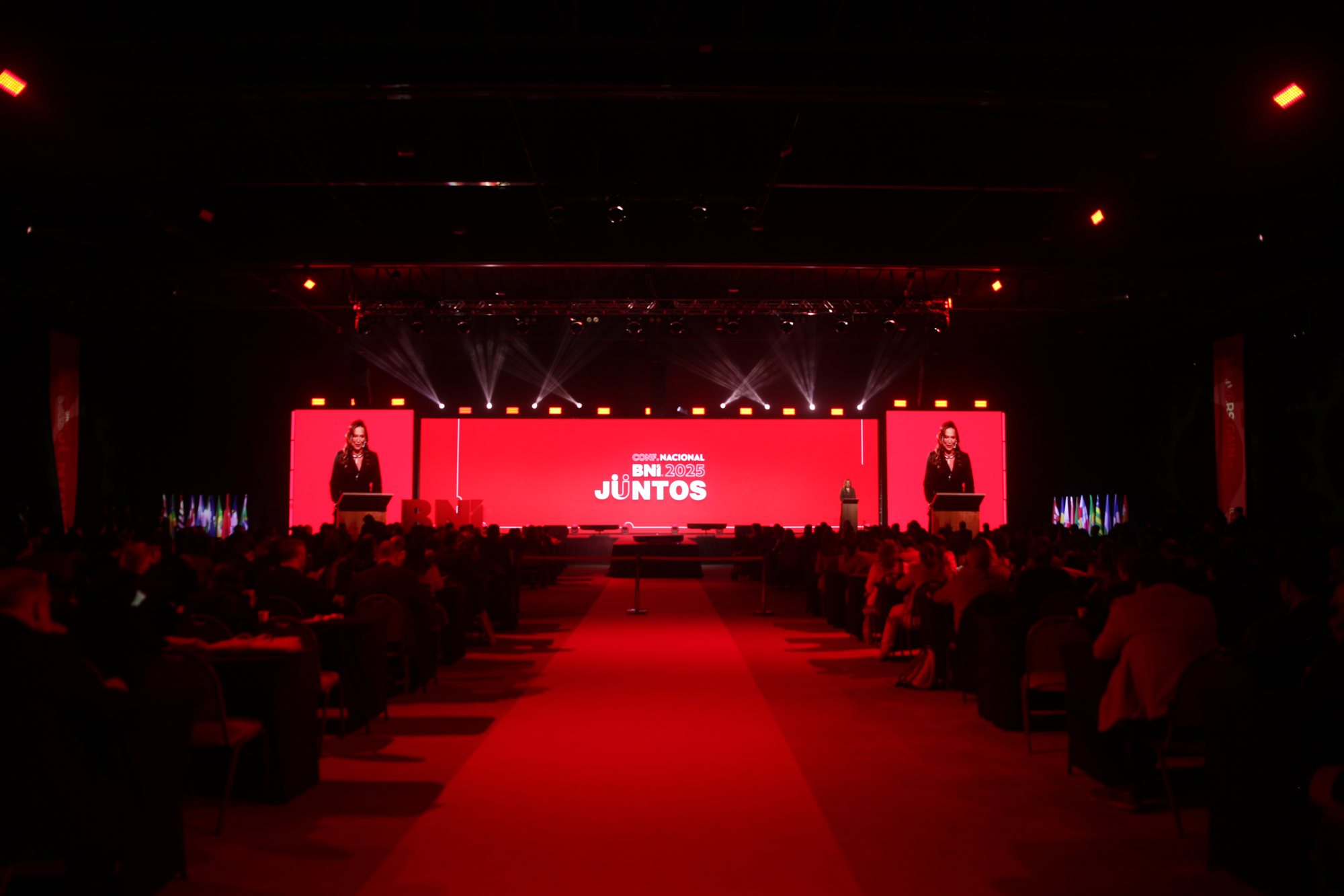 Palco da Conferência Nacional BNI Brasil 2025 com LED vermelho de 16 metros e plateia no Costão do Santinho
