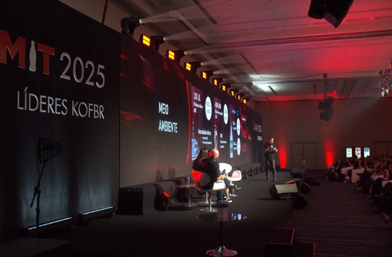 Palco da Convenção Coca-Cola FEMSA 2025 com LED, luz cênica e plateia em salão de hotel