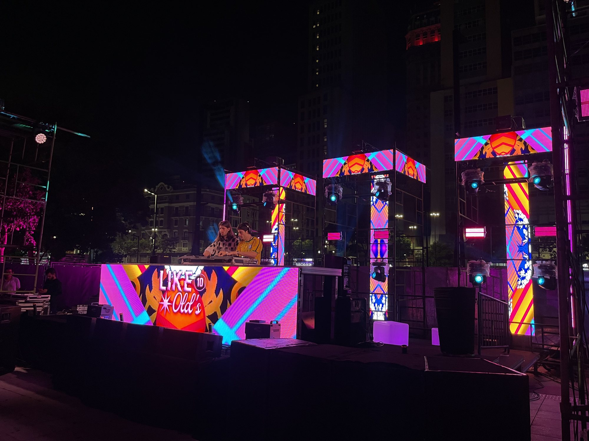 Palco da festa Like Old's na Praça das Artes com torres de andaime e painéis de LED