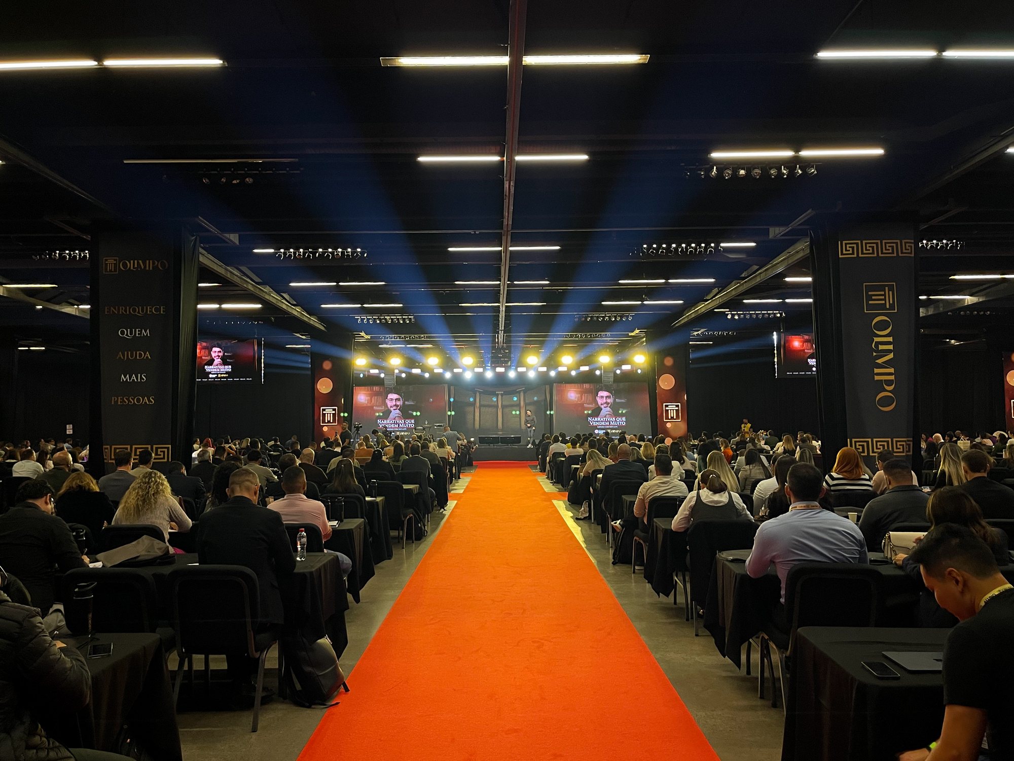 Salão do Olimpo 2025 com palco de LED, luz cênica e corredor central para a plateia