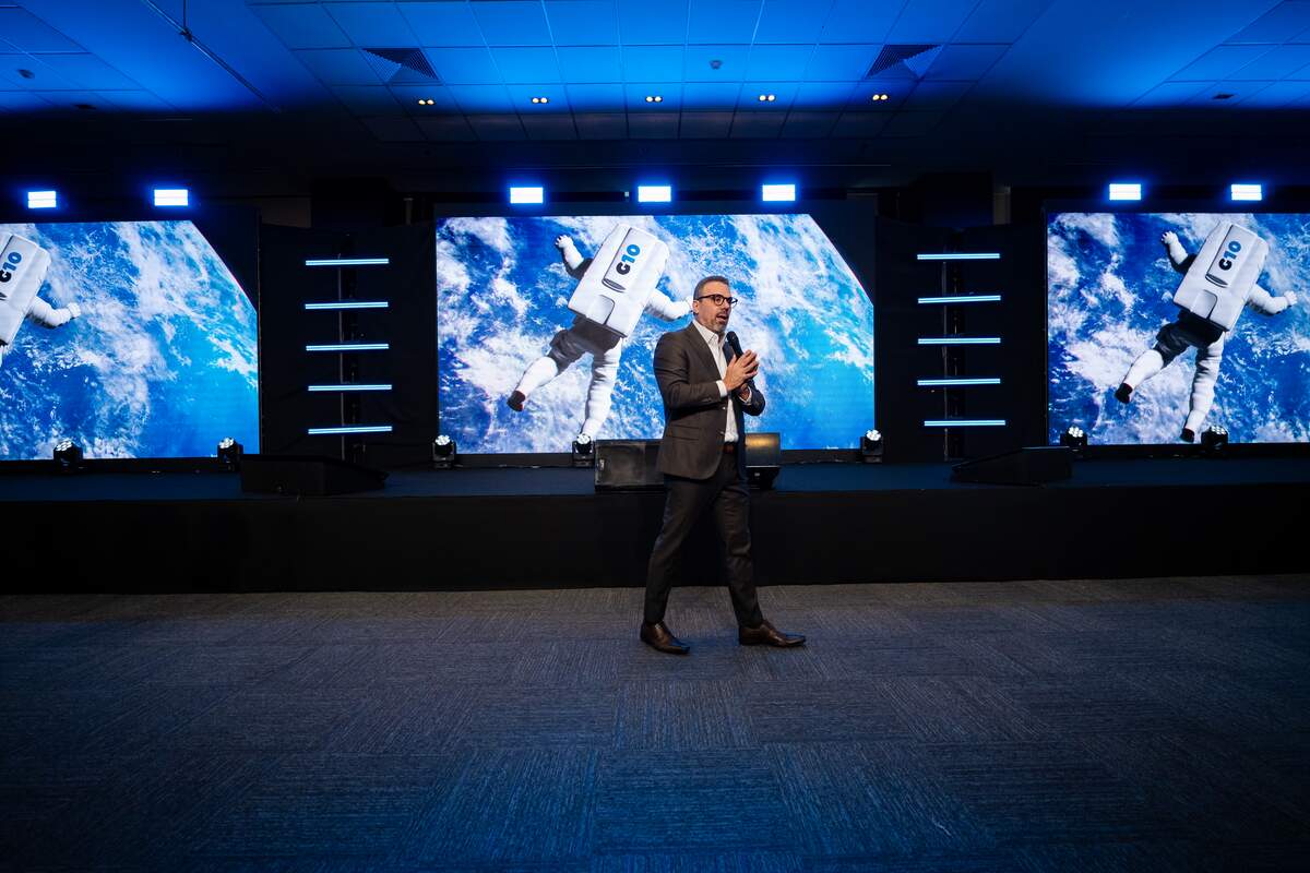 Palestrante em palco com três painéis de LED de imagem nítida e uniforme em evento corporativo